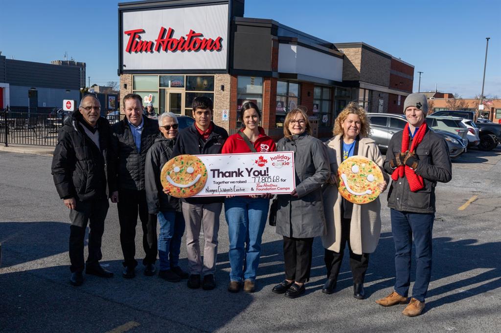 Group of people holding a cheque outside Tim Hortons